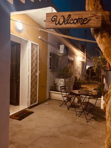a patio with chairs and a table and a welcome sign at Dream Holiday in Marina di Lizzano