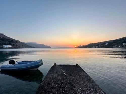 a boat tied to a dock in the water at sunset at Symi . VILLA CALME (Sur la Mer). in Symi