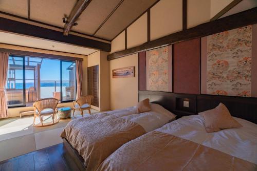 a bedroom with a bed and a view of the ocean at Isoaruki no Yuyado Ushiogumo -6 years or older- in Kawazu