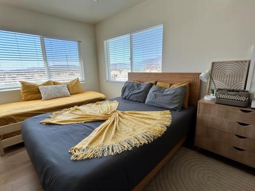 a bedroom with two beds and a dresser and windows at Modern & Private Desert Home w/ ez access and near Joshua Tree in Twentynine Palms