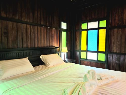 a bedroom with a bed and a stained glass window at Baan Koh Kwang Pool Villa Krabi in Krabi town