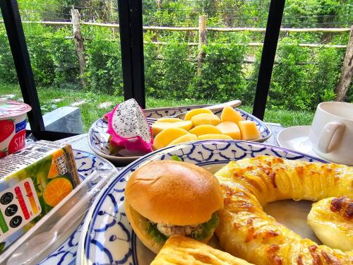 a plate of food with a sandwich and bread on a table at Baan Koh Kwang Pool Villa Krabi in Krabi town