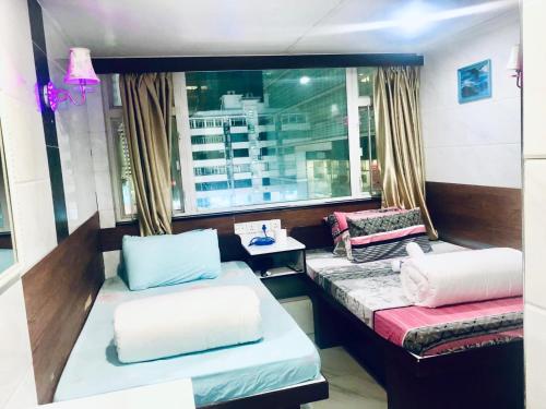 a room with two beds and a window at Asia inn (Block B) in Hong Kong