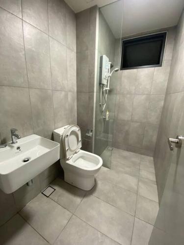 a bathroom with a toilet and a sink at Wonderful Home 2 Bedrooms By shkrnshh in Cheras
