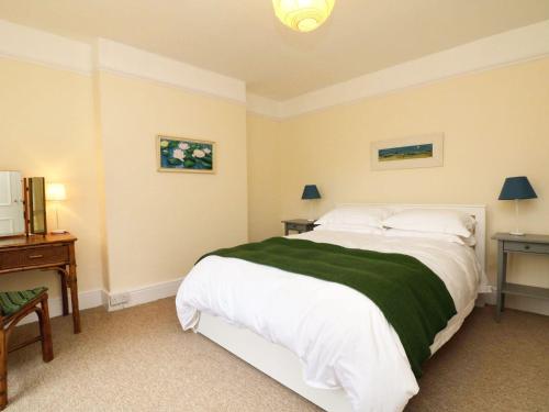 a bedroom with a large bed with a green blanket at Whites Meadow in Taunton