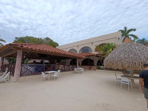 a building with chairs and tables and a straw umbrella at Bella Luxury Suite in Coronado in Playa Coronado