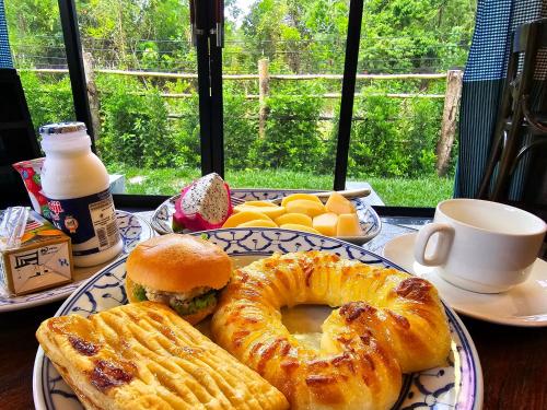 a plate of food with a sandwich and a bagel at Baan Koh Kwang Pool Villa Krabi in Krabi town