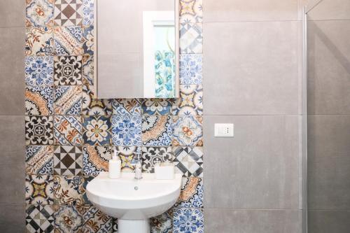 une salle de bain avec un lavabo et un miroir dans l'établissement Maddareti trilo, à Milazzo