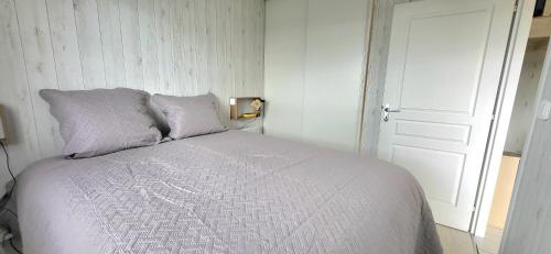 a white bed with two pillows in a bedroom at Appartement 1 chambre "Cocooning" in Jonzac
