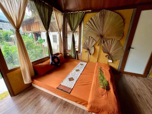duże łóżko w pokoju z oknami w obiekcie An's House w mieście Hà Giang