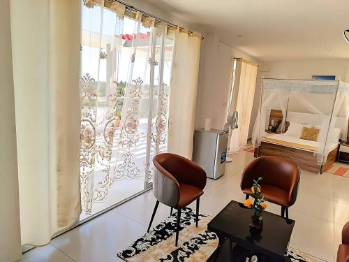 a living room with two chairs and a large window at Hary's Aparthotel in Toliara