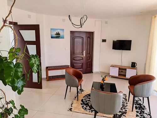- un salon avec des chaises et une télévision dans l'établissement Hary's Aparthotel, à Toliara