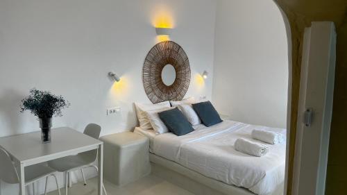 a bedroom with a bed with a mirror on the wall at Esmi Suites Santorini in Imerovigli