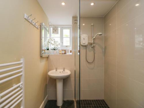 a bathroom with a sink and a shower at Beck Cottage in Ulverston