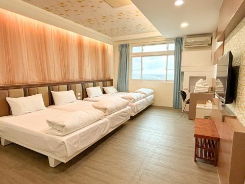 a living room with two beds and a television at 綠島海灣會館Bay Resort in Green Island