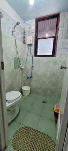 a bathroom with a shower and a toilet at Home Sweetie Homestay & Bunkbeds in Moalboal