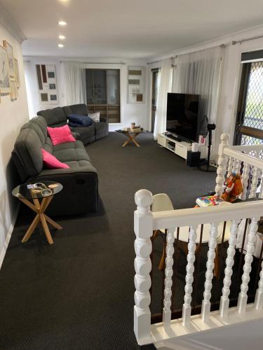 a living room with a couch and a tv at Everingham Views in Rockhampton