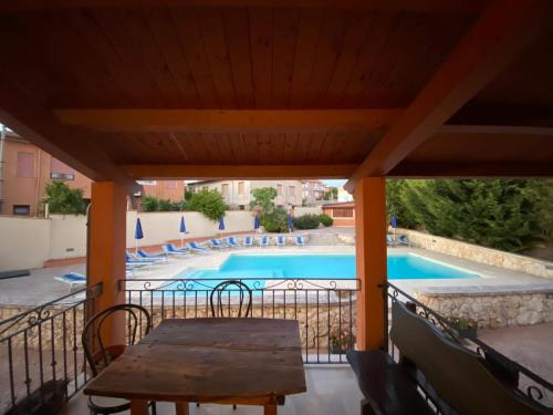 a patio with a table and a swimming pool at Piccola Locanda S'Ausentu in Uri
