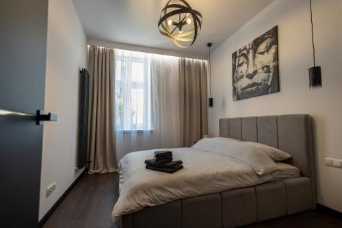 a bedroom with a bed and a chandelier at Apartament Prestige in Nowy Sącz