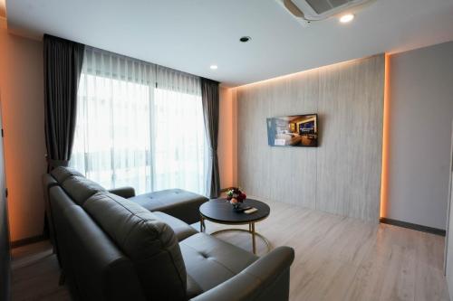 a living room with a couch and a table at โรงแรมออร่า สงขลา in Hat Yai