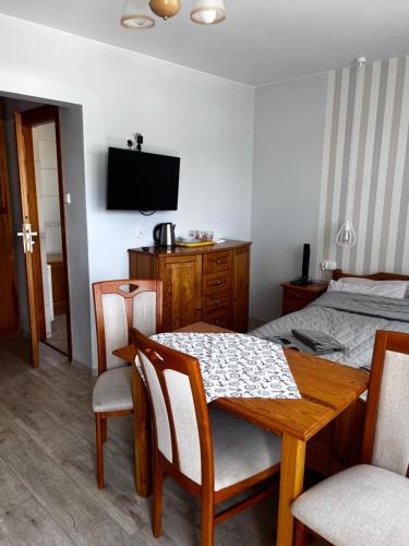 a room with a dining table and a bed at Szyper in Jastarnia