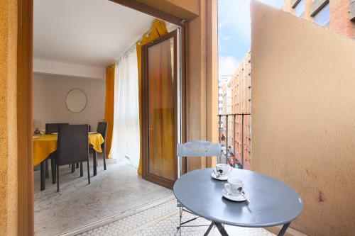 Cette chambre comprend une petite table et un balcon. dans l'établissement Le jaune Place Saint Georges 100m Parking Terrasse, à Toulouse