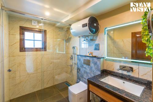 a bathroom with a shower and a sink and a shower at StayVista at Swiss Chalet - Tangmarg with Gazebo & Lawn in Tangmarg