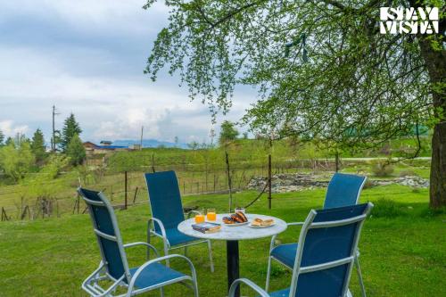 a table and chairs with food on it in the grass at StayVista at Swiss Chalet - Tangmarg with Gazebo & Lawn in Tangmarg
