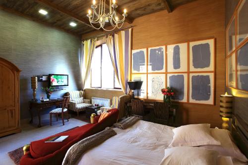 um quarto com uma cama, uma secretária e uma janela em Hotel Boutique Palacio de la Serna em Ballesteros de Calatrava