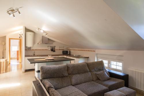 sala de estar con sofá y cocina en Spa Rural Mirador de Miranda, en Cutiellos