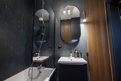 a bathroom with two sinks and a mirror and a tub at Apartament Prestige in Nowy Sącz
