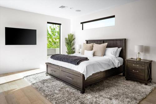 a bedroom with a large bed and a tv at NEW Modern 3BR & Loft- Heated pool, Near airport in Phoenix