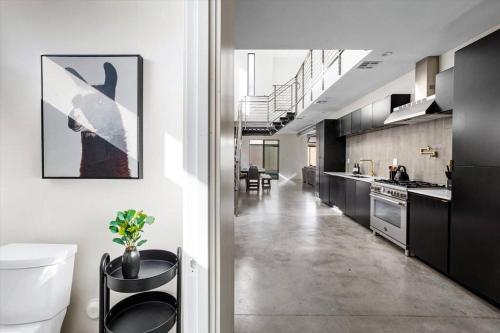 a large kitchen with black cabinets and a hallway at NEW Modern 3BR & Loft- Heated pool, Near airport in Phoenix