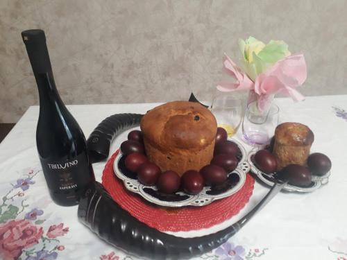 una mesa con un plato de comida y una botella de vino en House at the Forest / სახლი ტყის პირას, en Gordi
