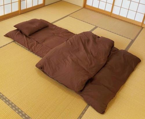 two brown pillows on the floor of a room at 森の空気を感じる宿泊 露天風呂 Wi-Fi 最大20名様 in Shima