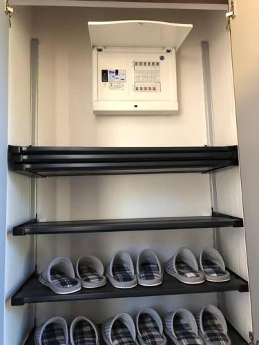 Una fila de zapatos en los estantes de un refrigerador. en 森の空気を感じる宿泊 露天風呂 Wi-Fi 最大20名様, en Shima