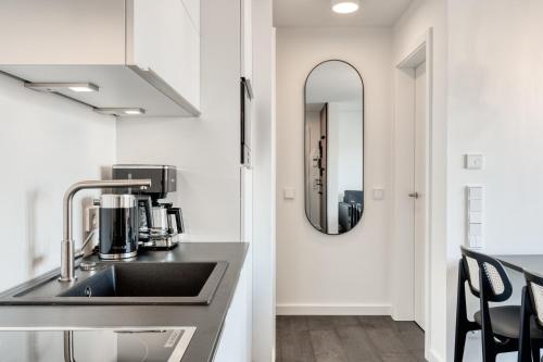 a kitchen with a sink and a mirror at Haus Noena in Norderney