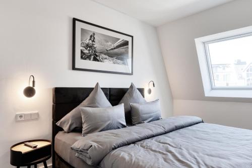 a bedroom with a bed with pillows and a window at Haus Noena in Norderney