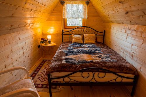 1 dormitorio con 1 cama en una cabaña de madera en Chata Czarny Kot, en Janowice Wielkie
