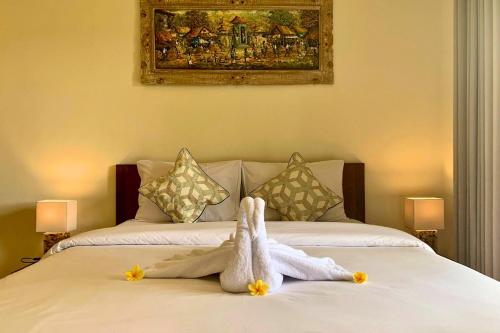 a stuffed animal is sitting on a bed at Gria Sindhu Homestay Sidemen by AGATA in Sidemen