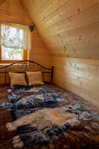 a bedroom with a bed in a log cabin at Chata Czarny Kot z jacuzzi i sauną in Janowice Wielkie