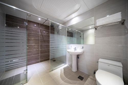 uma casa de banho com um WC, um lavatório e um chuveiro em GyeongJu Kids & Family Hotel em Gyeongju