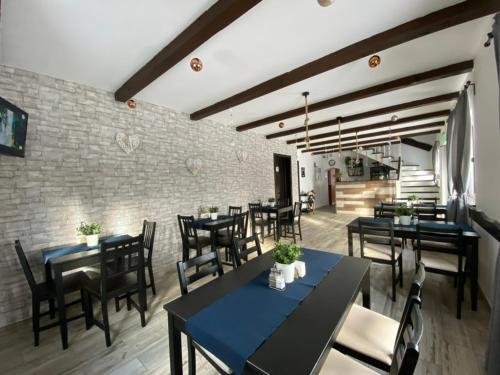 a restaurant with black tables and chairs and a brick wall at Casa Ambra in Sadova