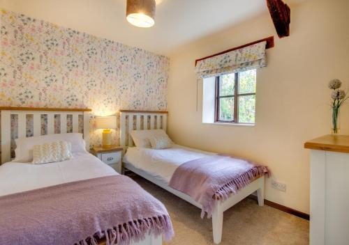 LlanerchymeddにあるOwl Cottageのベッドルーム1室(ベッド2台、窓付)