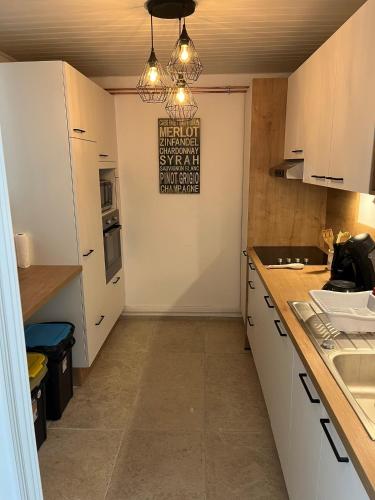 a kitchen with white cabinets and a light fixture at Bayeux in Bayeux