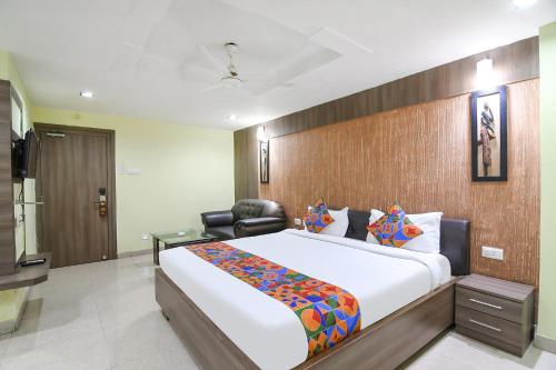 a hotel room with a large bed and a chair at FabHotel Raj Residency II in Rānchī