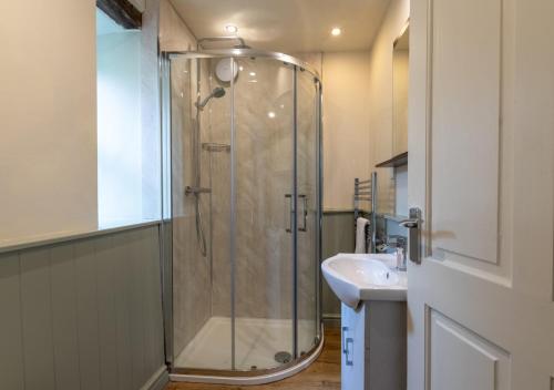 uma casa de banho com um chuveiro e um lavatório. em The Barn em Llanerchymedd