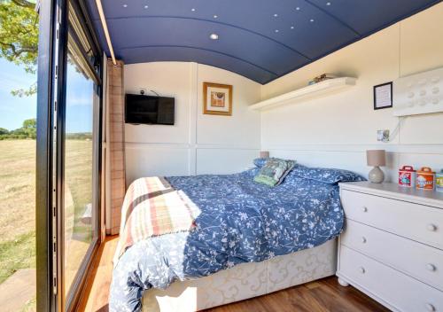 a bedroom with a bed in a tiny house at Shepherds Hut at Ridge Hall in Staithes