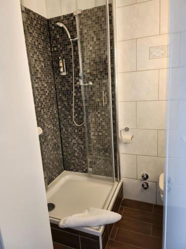 Das Bad ist mit einer Dusche und einer Badewanne ausgestattet. in der Unterkunft Hotel Willert in Wismar