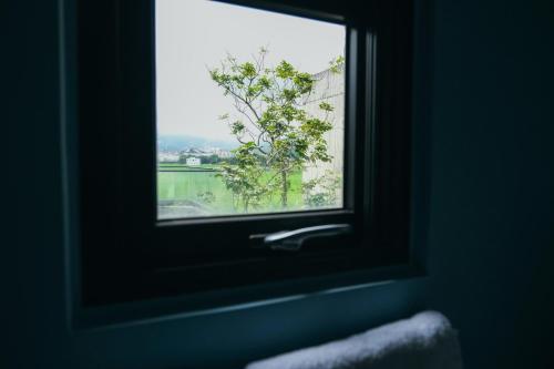 a window in a room with a view of a lake at 樹墅Villa宜蘭寵物友善包棟民宿丨溜滑梯丨烤肉丨Switch in Ch'eng-hsing